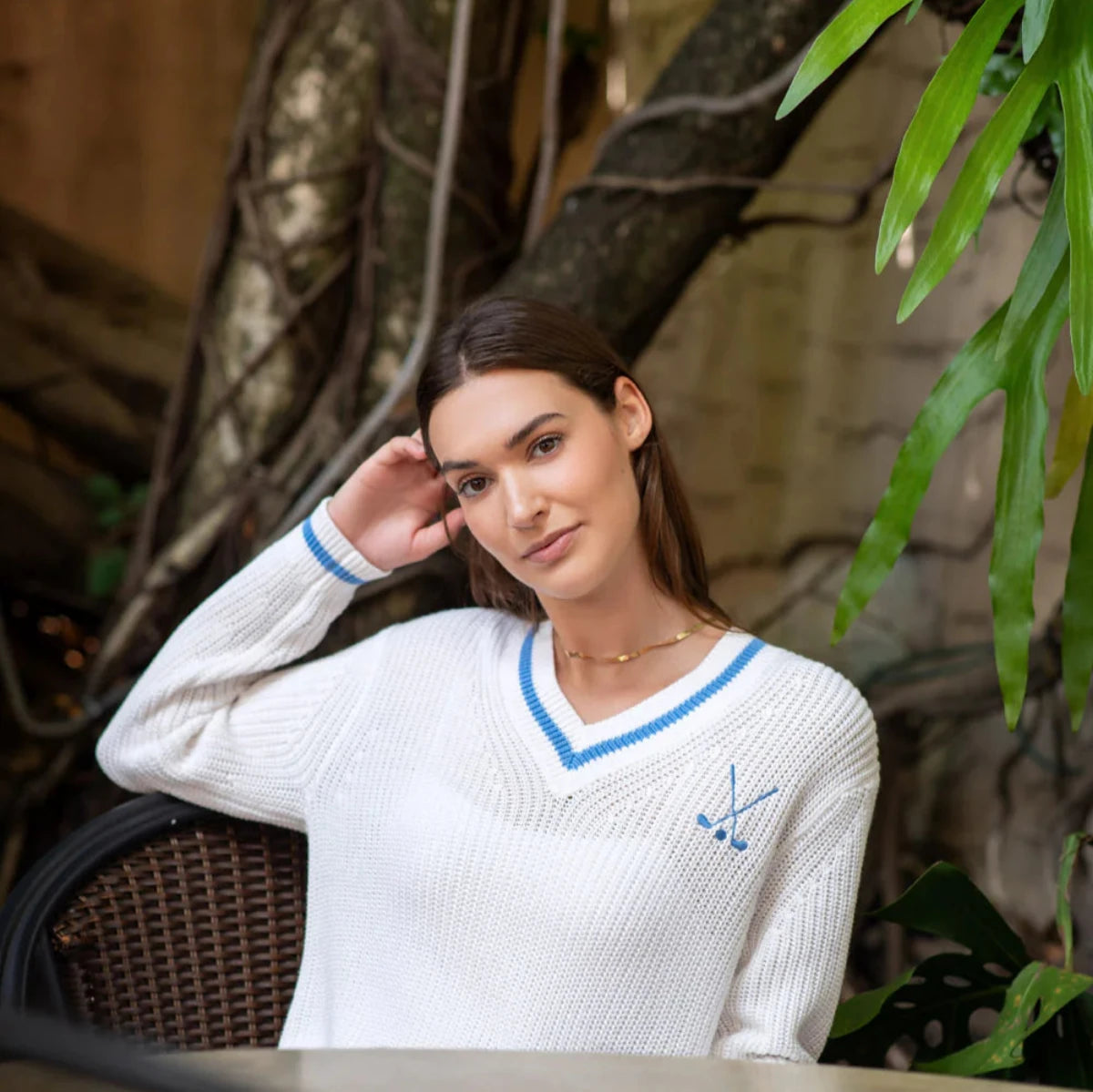 lightweight white knit sweater with baby blue varsity trim and embroidered golf clubs logo