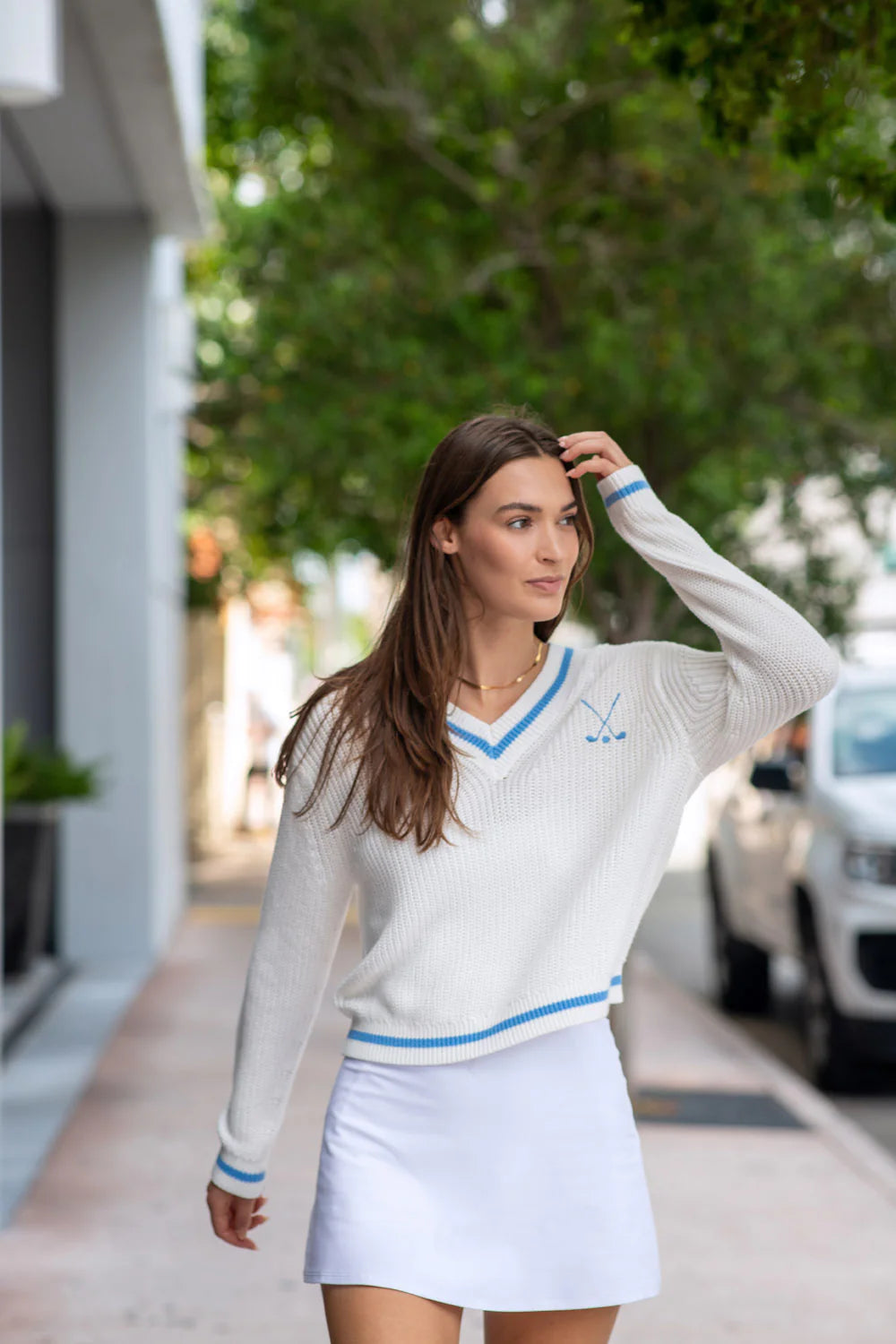 lightweight white knit sweater with baby blue varsity trim and embroidered golf clubs logo