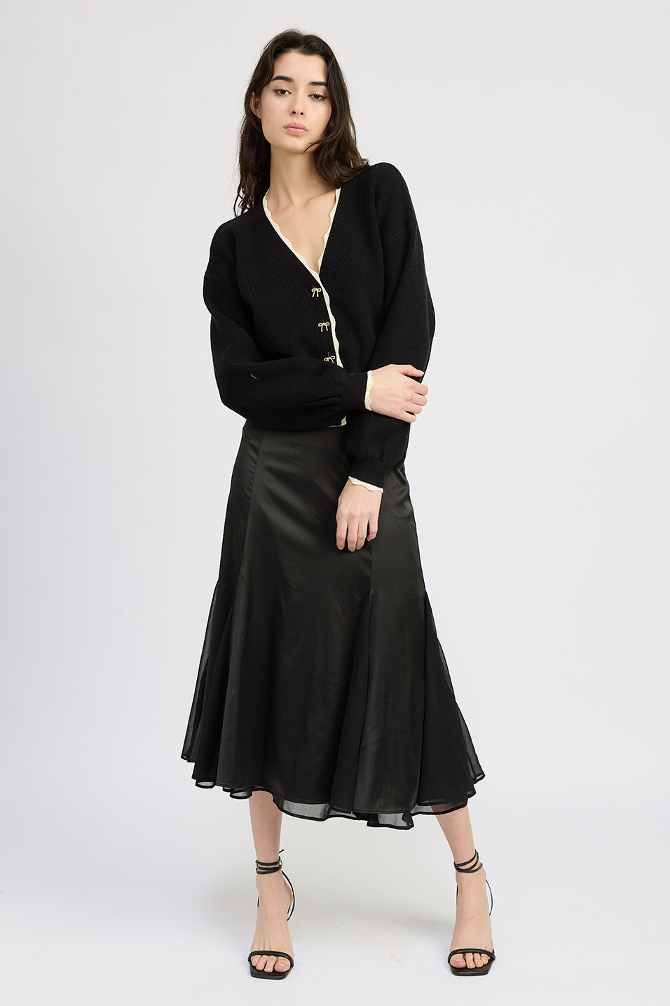 black cardigan with gold bow buttons and puffed long sleeves