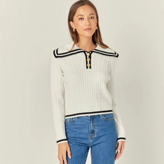 white cable knit sweater with wide sailor collar and black piping and 3 gold buttons