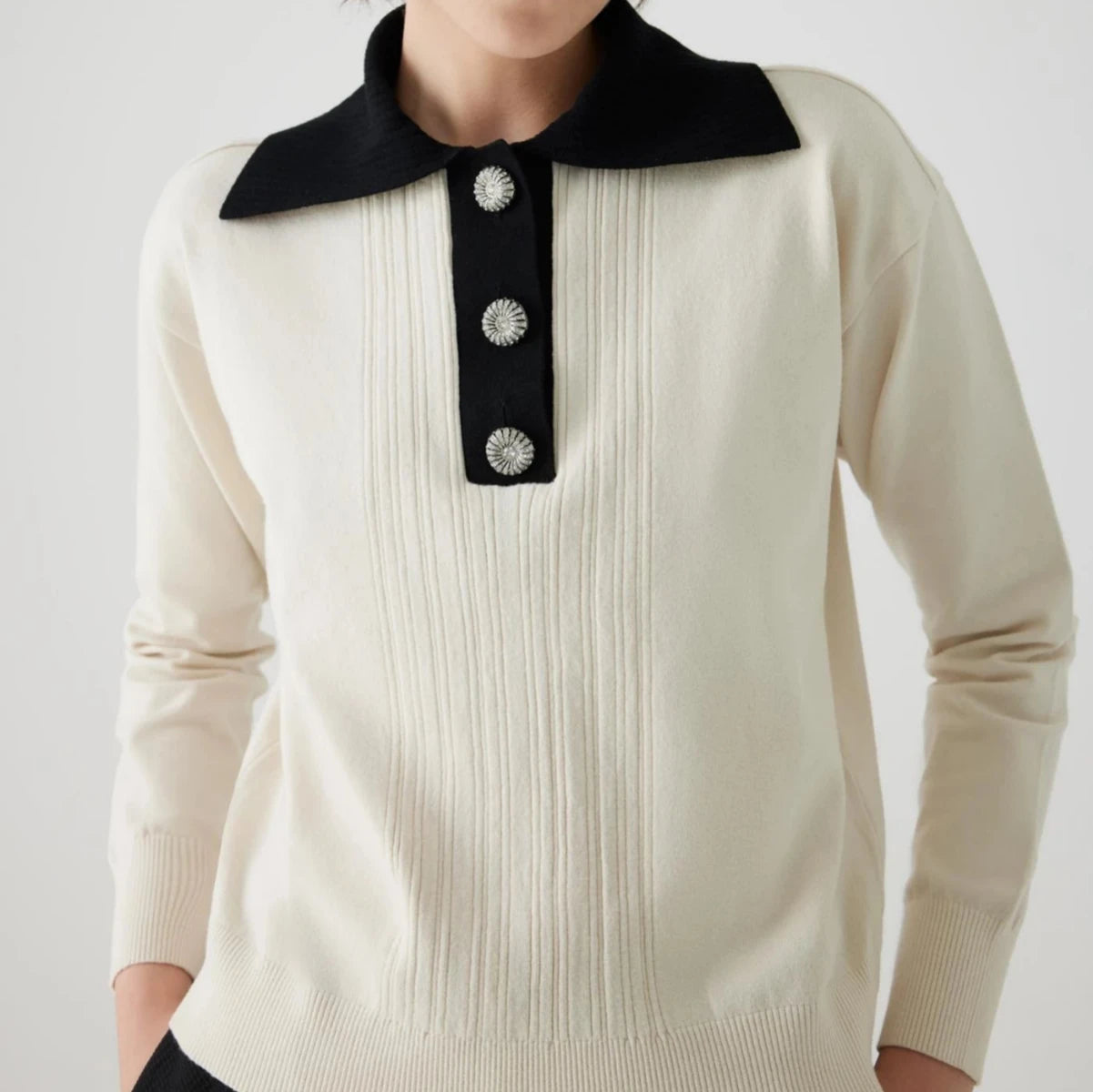 ivory knit pullover with black contrasting collar and bejeweled buttons