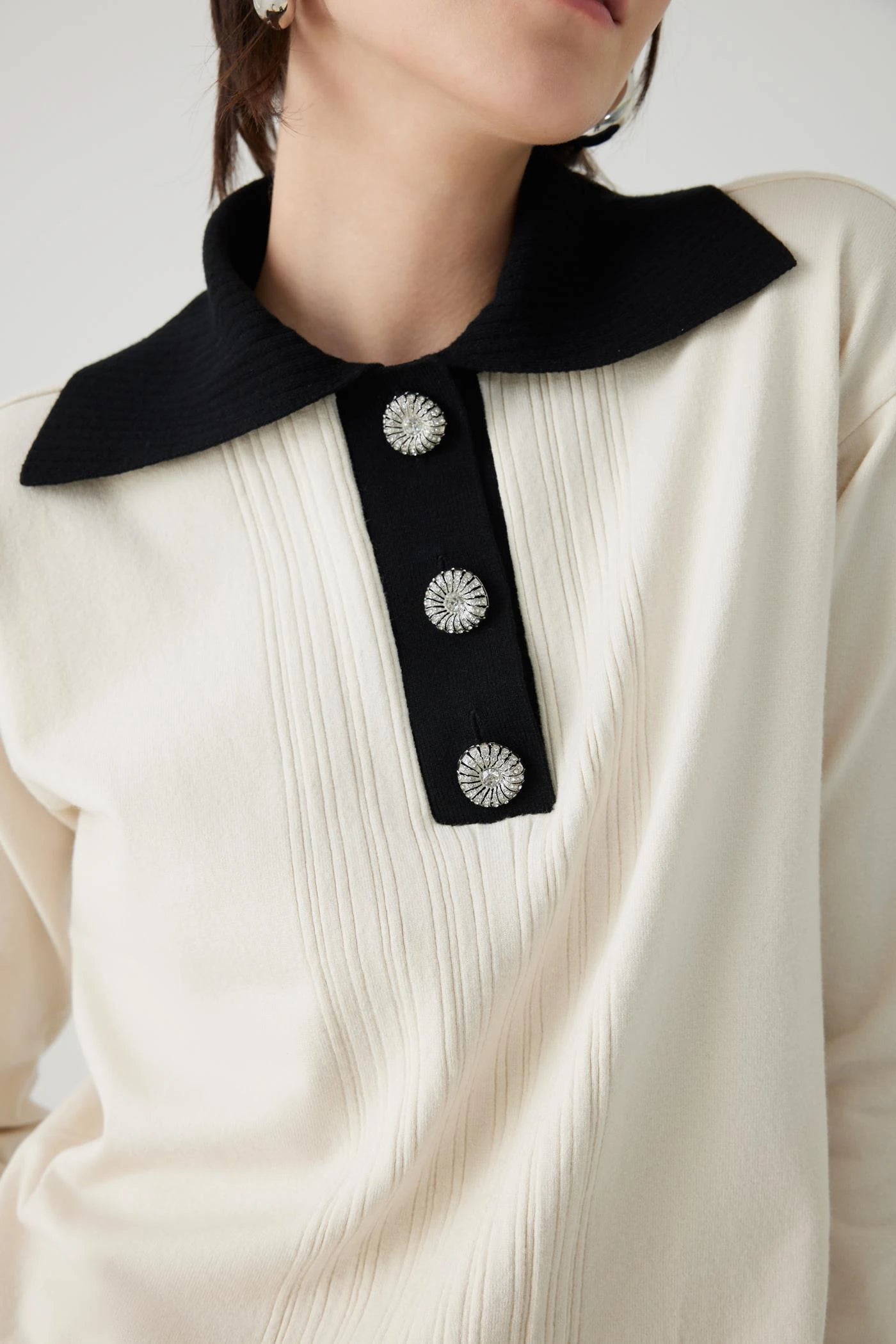 ivory knit pullover with black contrasting collar and bejeweled buttons