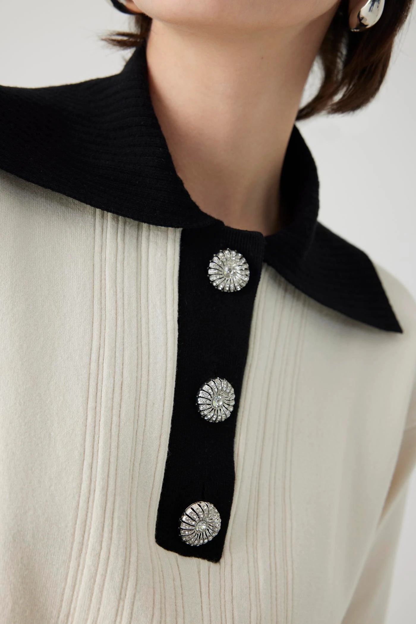 ivory knit pullover with black contrasting collar and bejeweled buttons