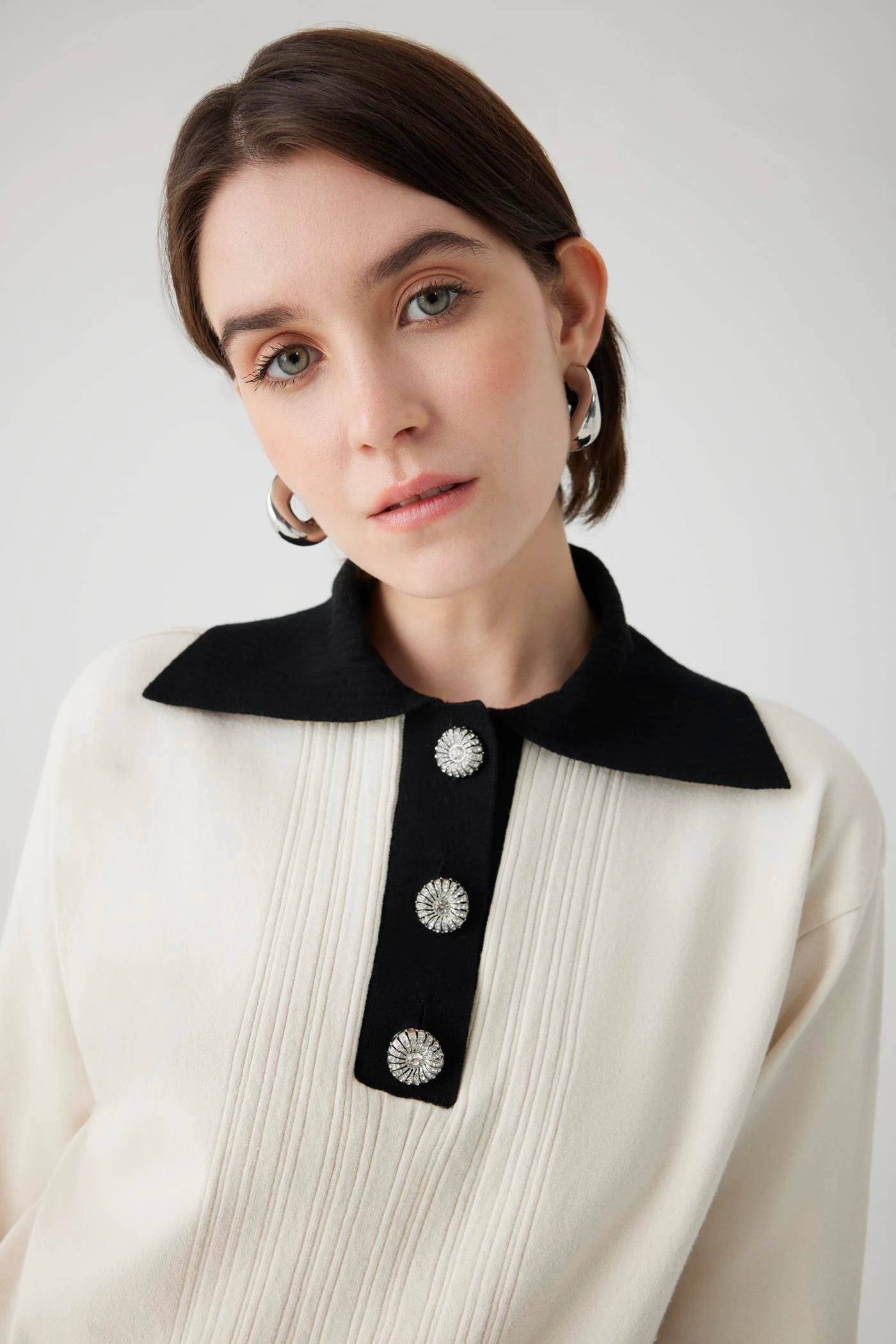 ivory knit pullover with black contrasting collar and bejeweled buttons