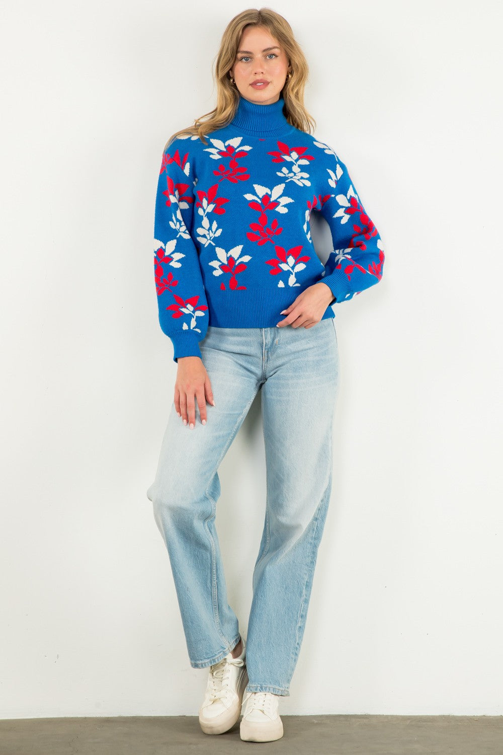 bright blue turtleneck sweater with red and white abstract floral pattern and puffed long sleeves