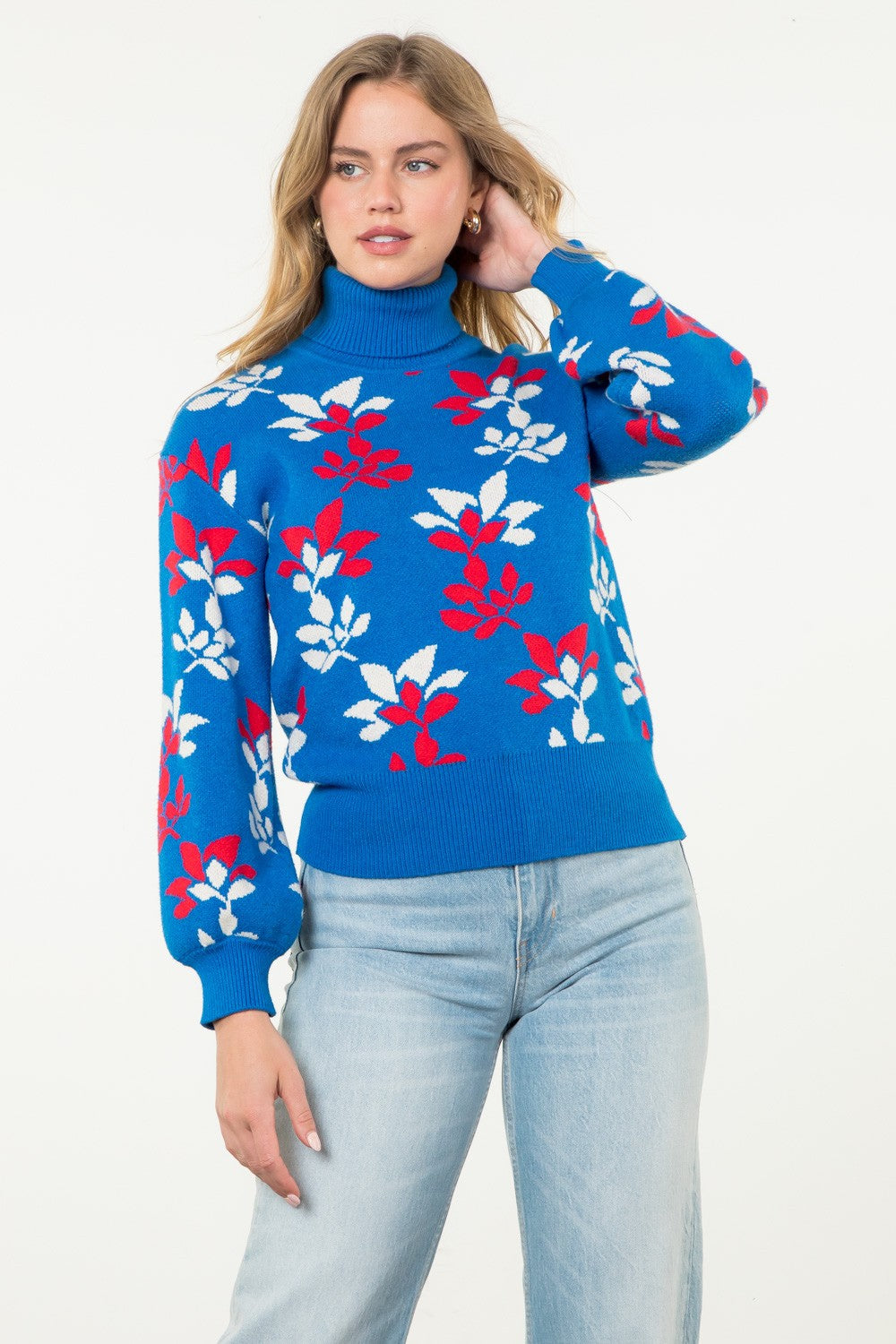 bright blue turtleneck sweater with red and white abstract floral pattern and puffed long sleeves