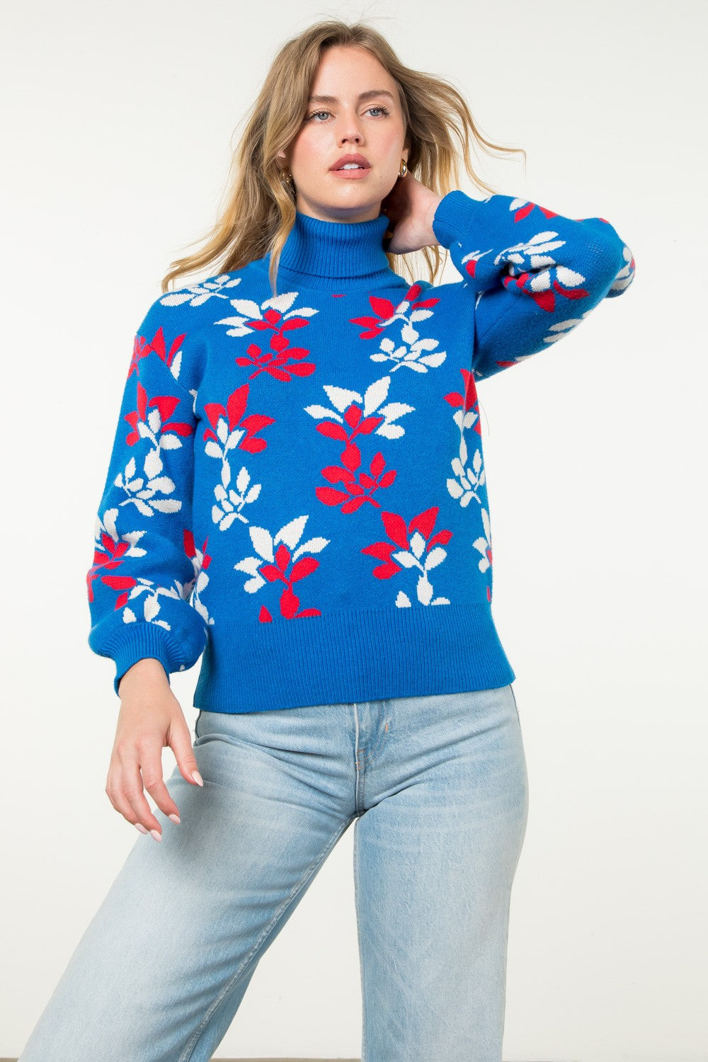 bright blue turtleneck sweater with red and white abstract floral pattern and puffed long sleeves