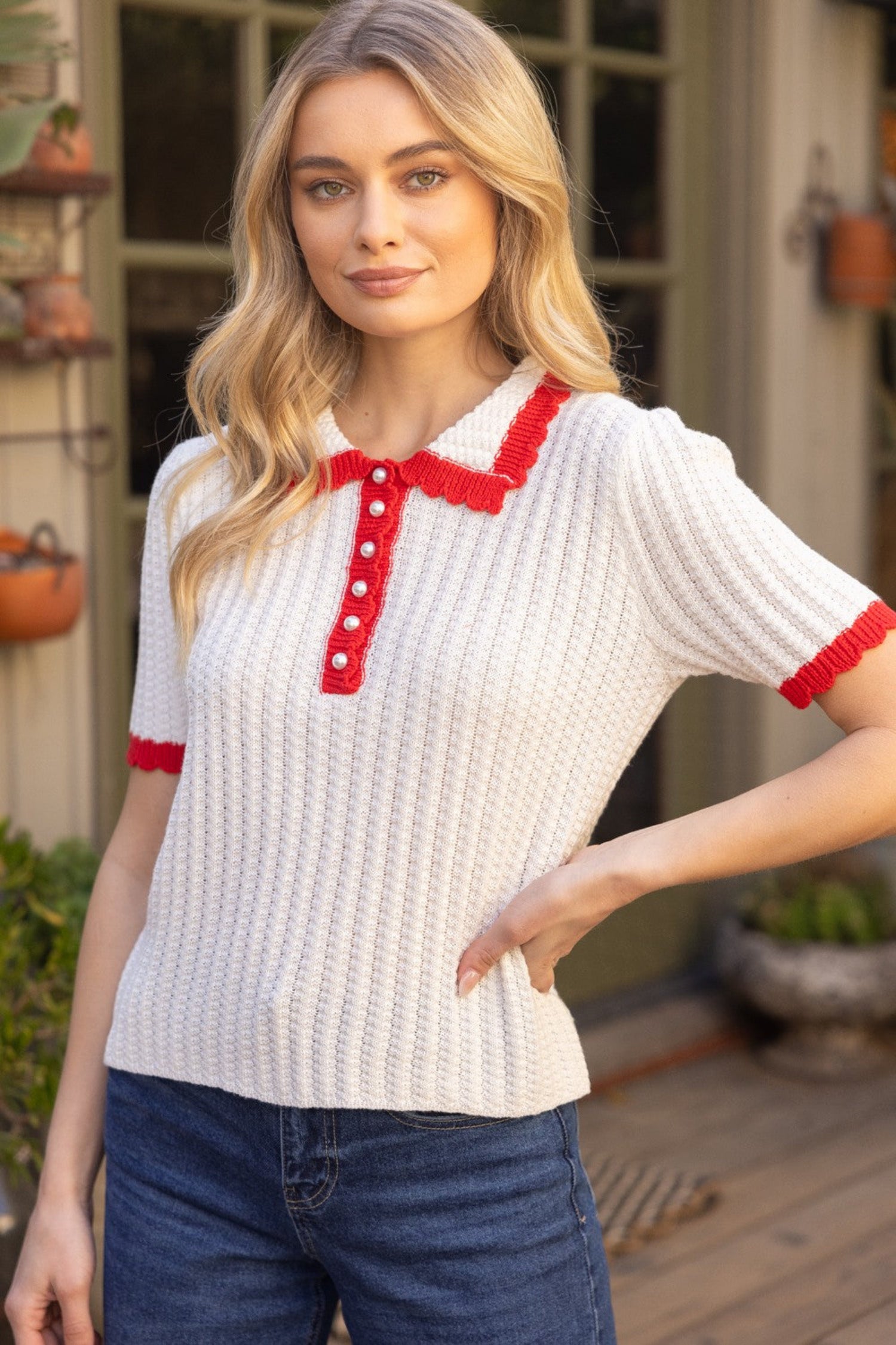 ivory knit short sleeve polo top with red trim, collar and pearl buttons